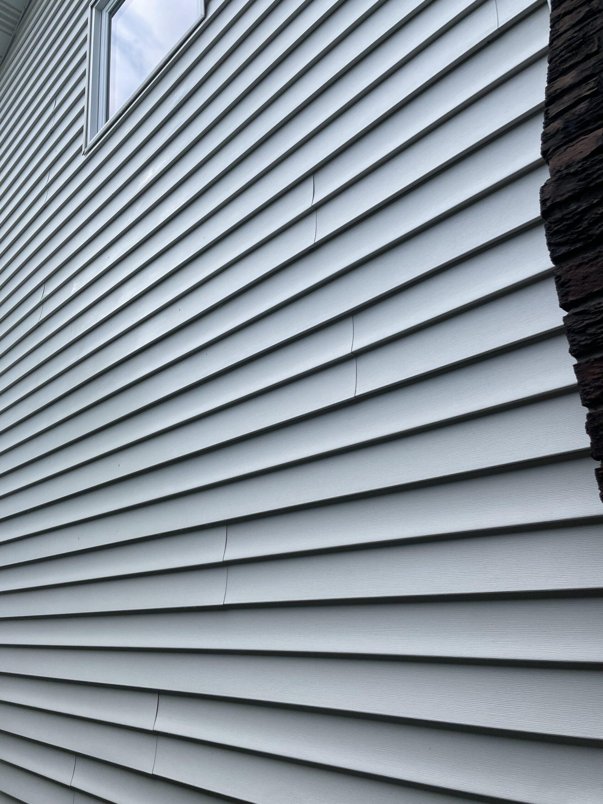 Professional pressure washing restoring clean exterior siding on a residential home